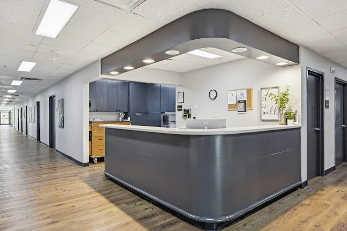 Modern reception desk in bright hallway with wood floors