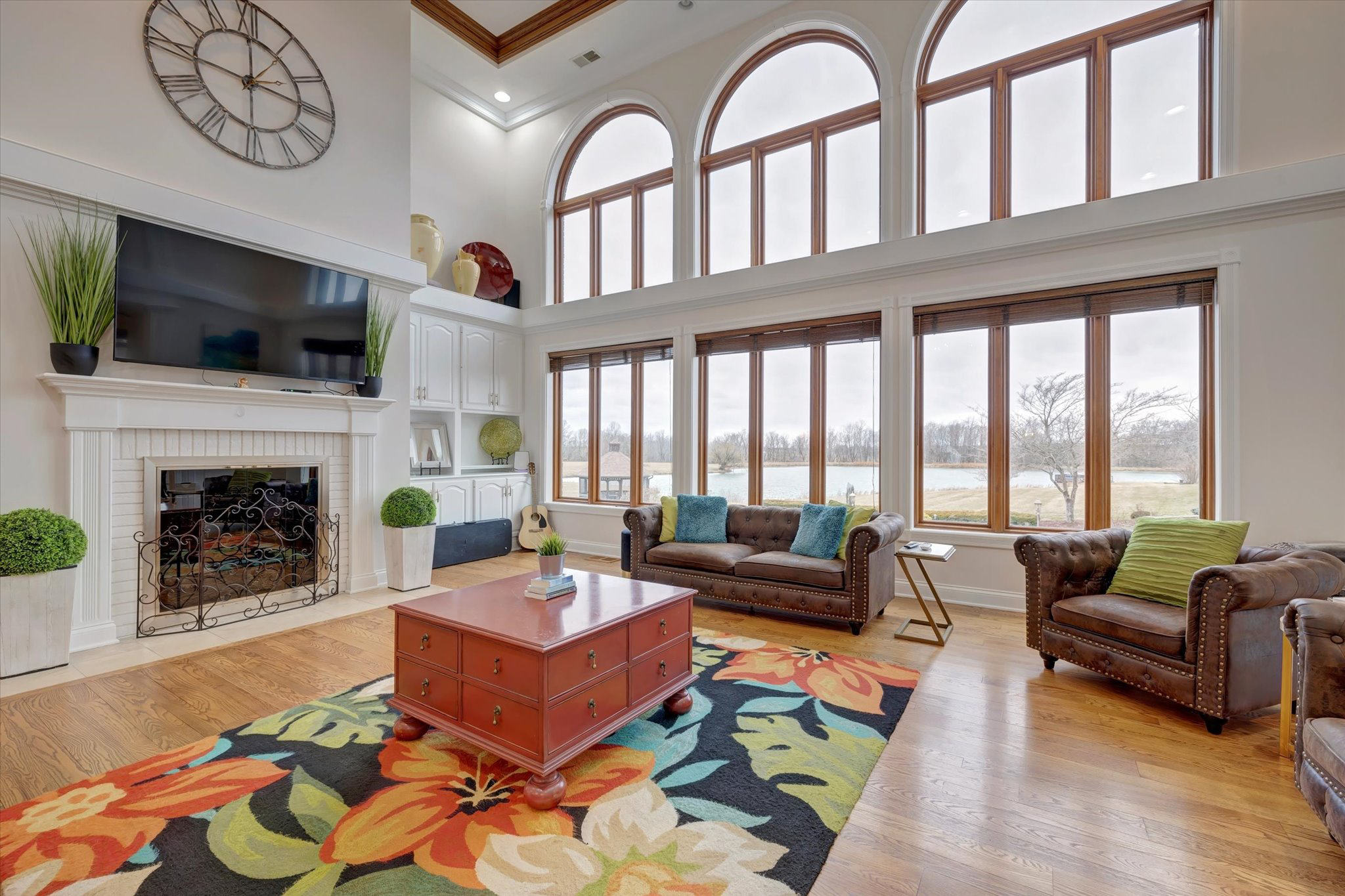 Spacious den with sofas, fireplace, and lake views