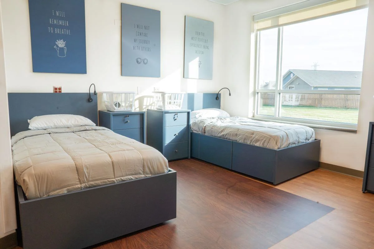 Bright shared room with two twin beds and large window