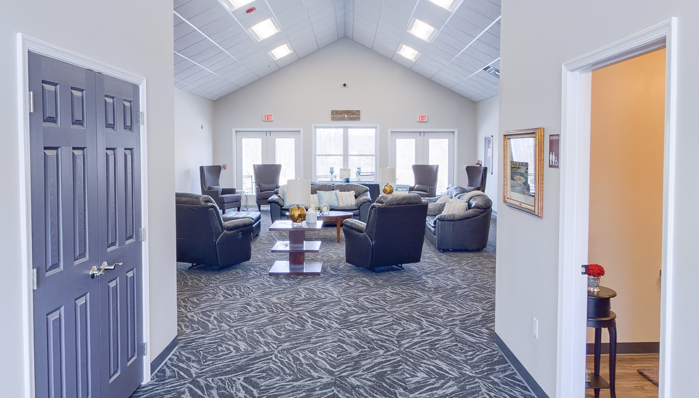 Spacious lounge with sofas, armchairs, and vaulted ceiling