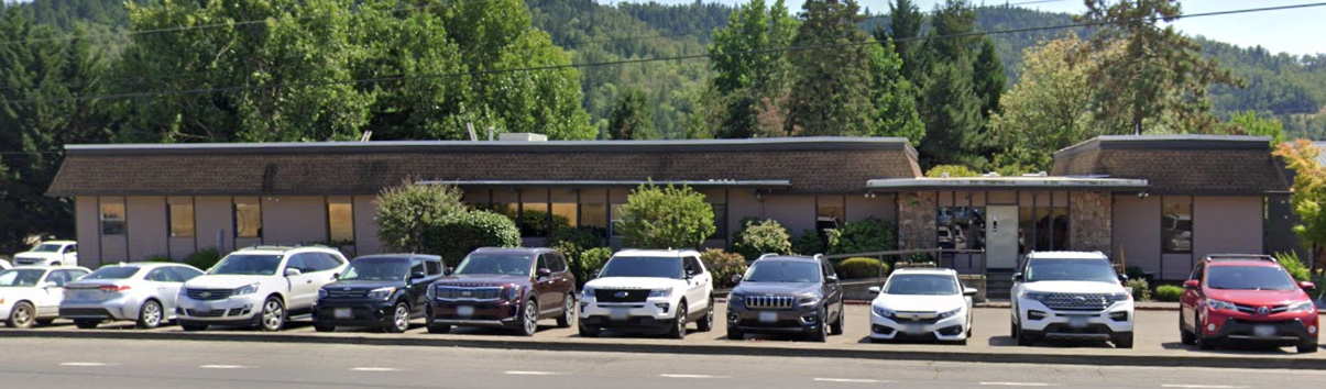 Rehab facility with parking lot and cars in front of main building
