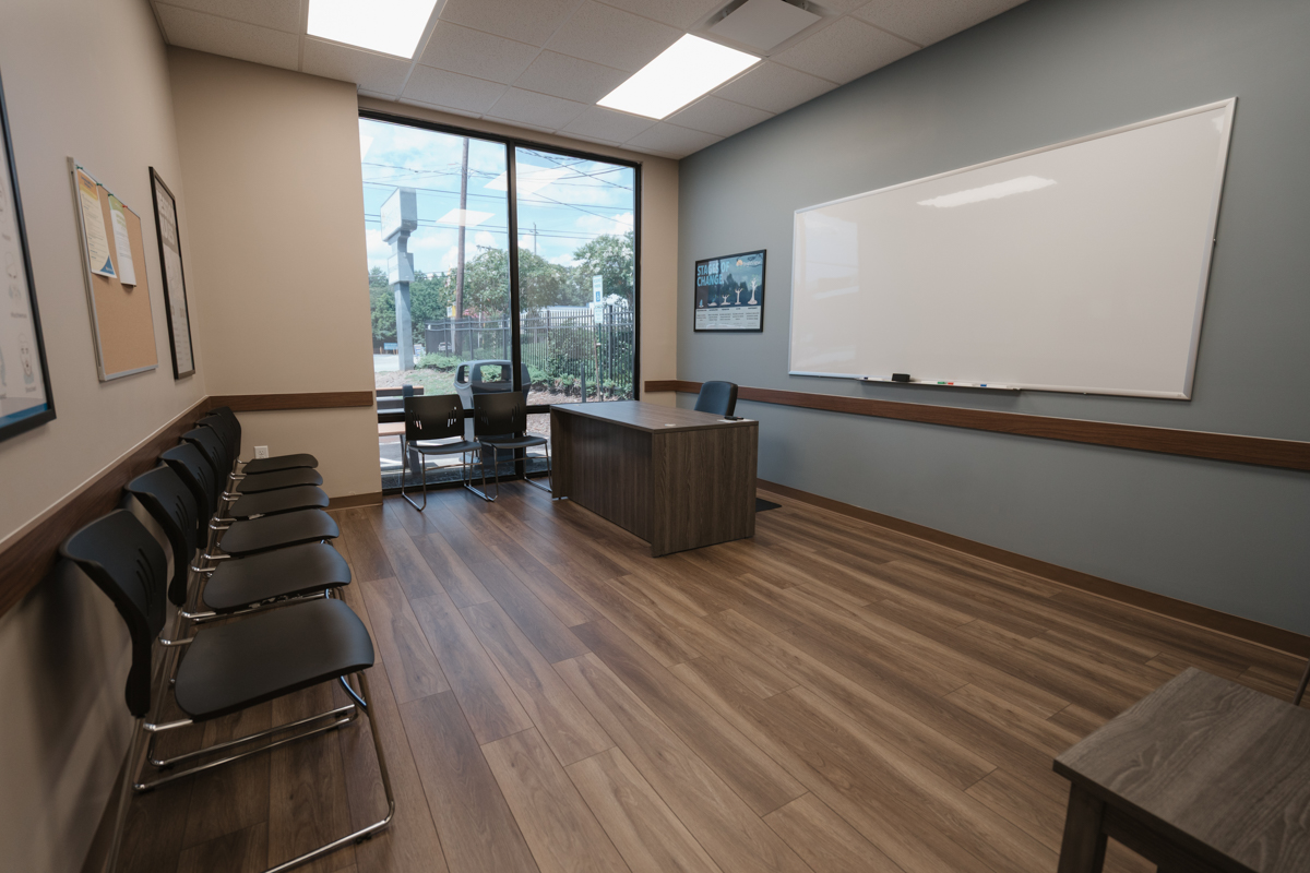Group room with chairs, large whiteboard, and front desk