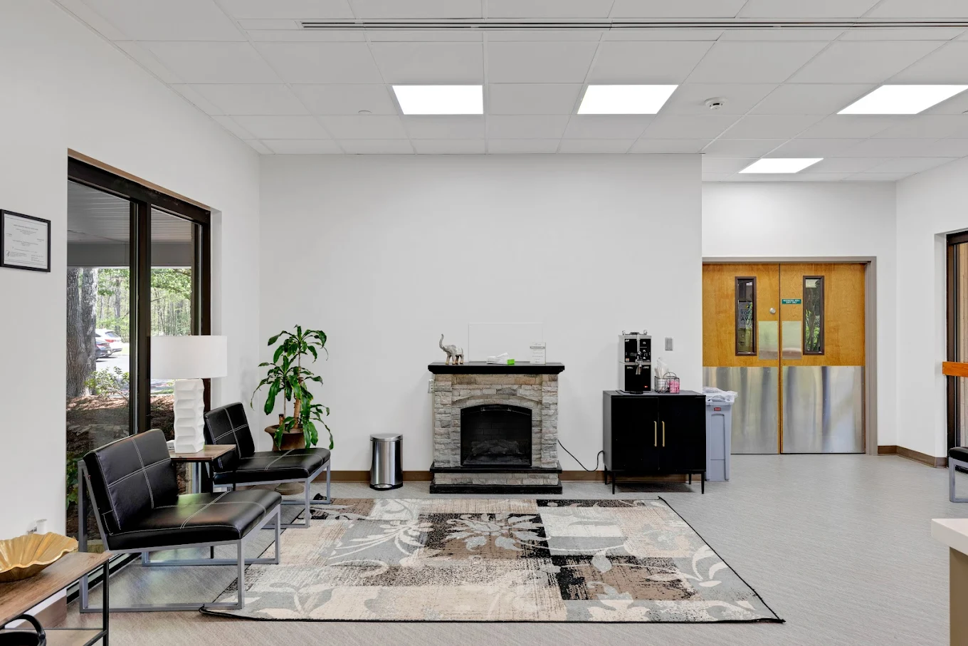 Waiting area with seating, fireplace, and natural light