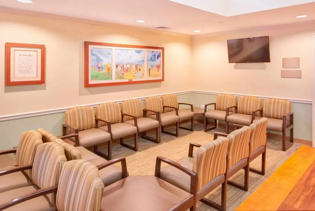 Comfortable waiting room with seating and wall-mounted TV