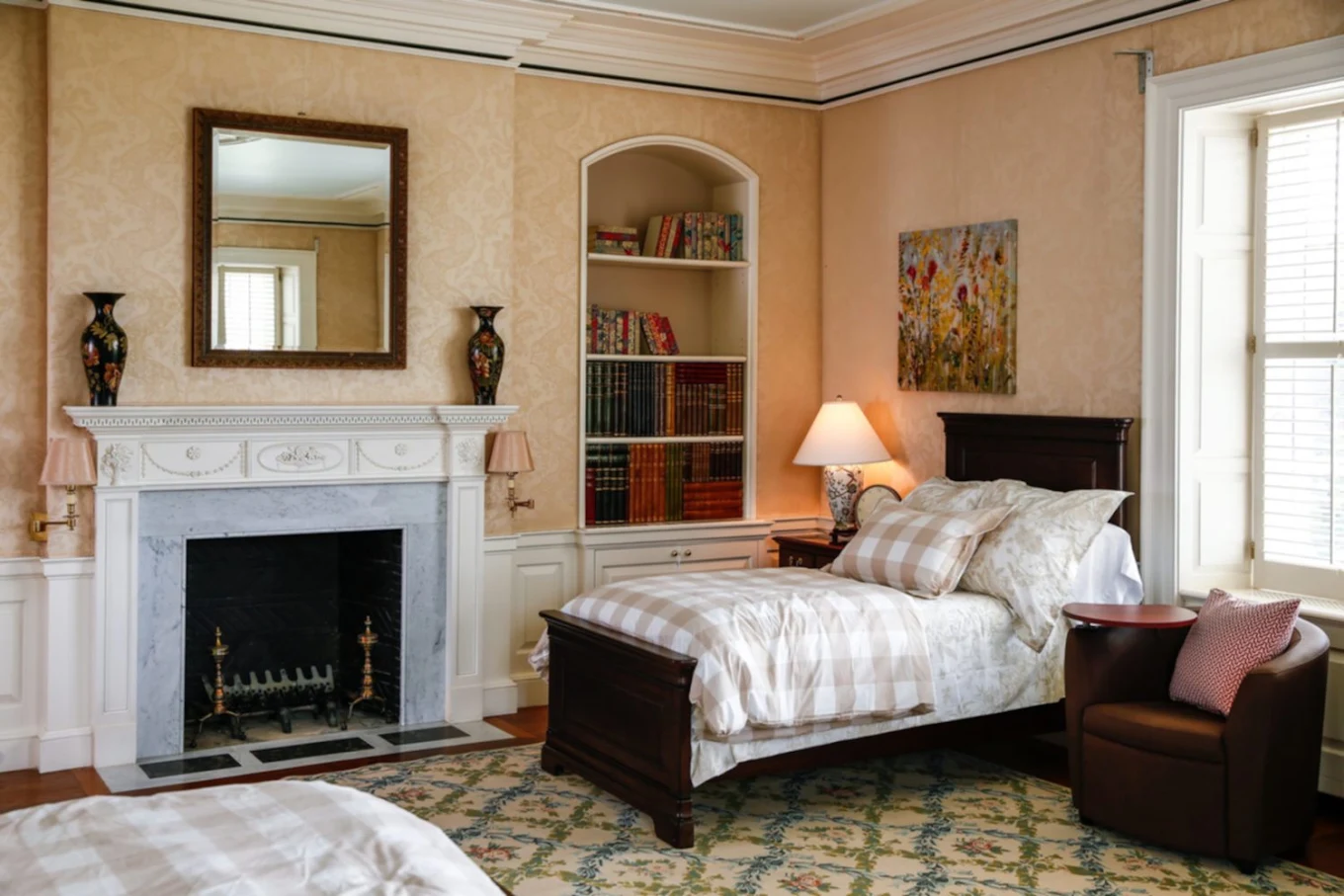 Bedroom with bed, fireplace, armchair, and large windows