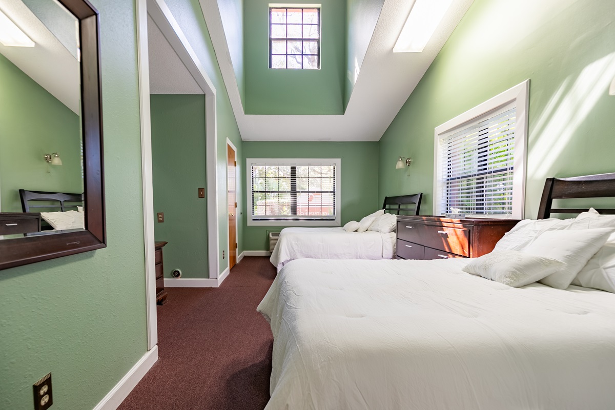 Bright room with two beds and green walls