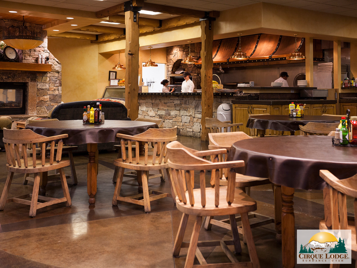 Rustic dining room with wooden tables near open kitchen