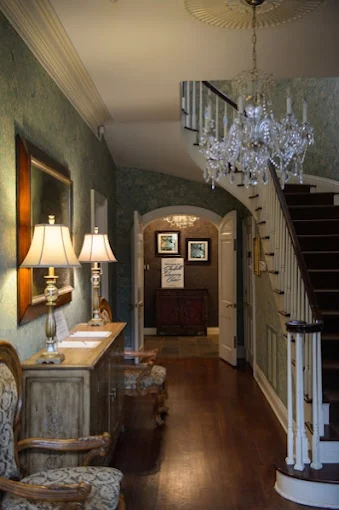 Wood-floored hallway with chandelier and stairs