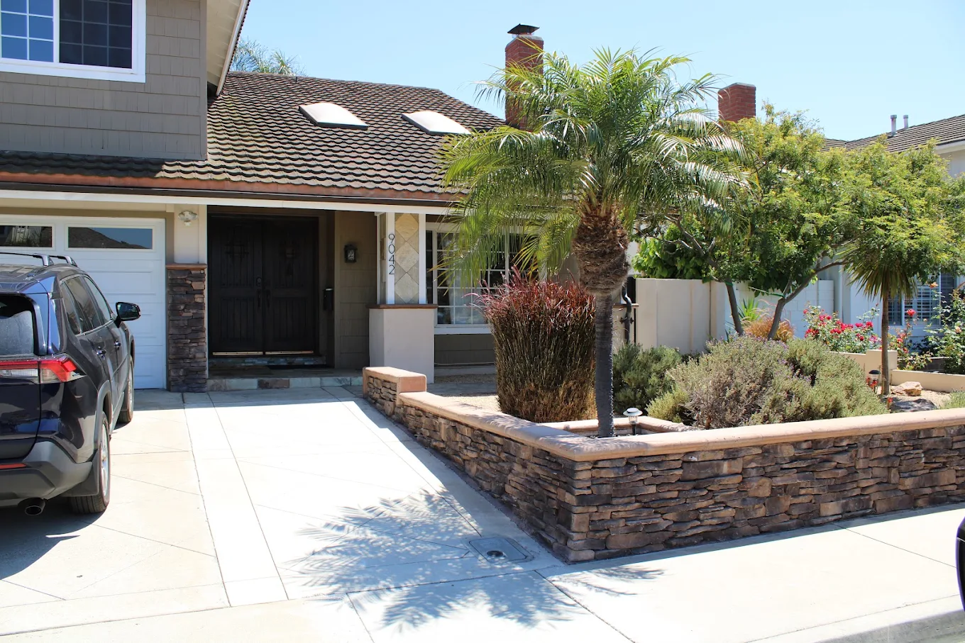 Facility entrance with landscaped courtyard and palm trees