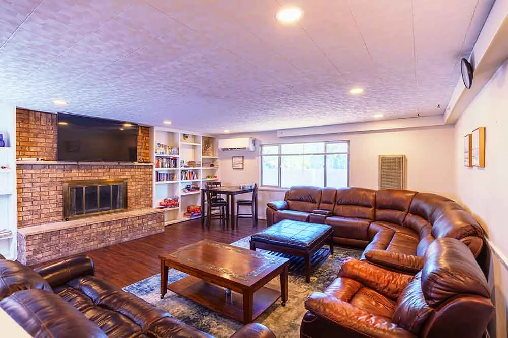 Cozy lounge with leather couches, fireplace, and TV