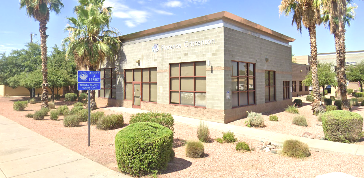 Front view of Florence Crittenton Therapeutic Group Home in Phoenix with palm trees and desert plants.