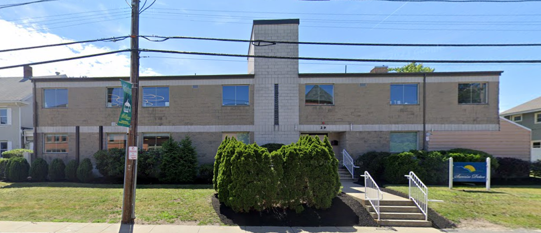 Entrance  with green lawn and stairs leading to entrance.