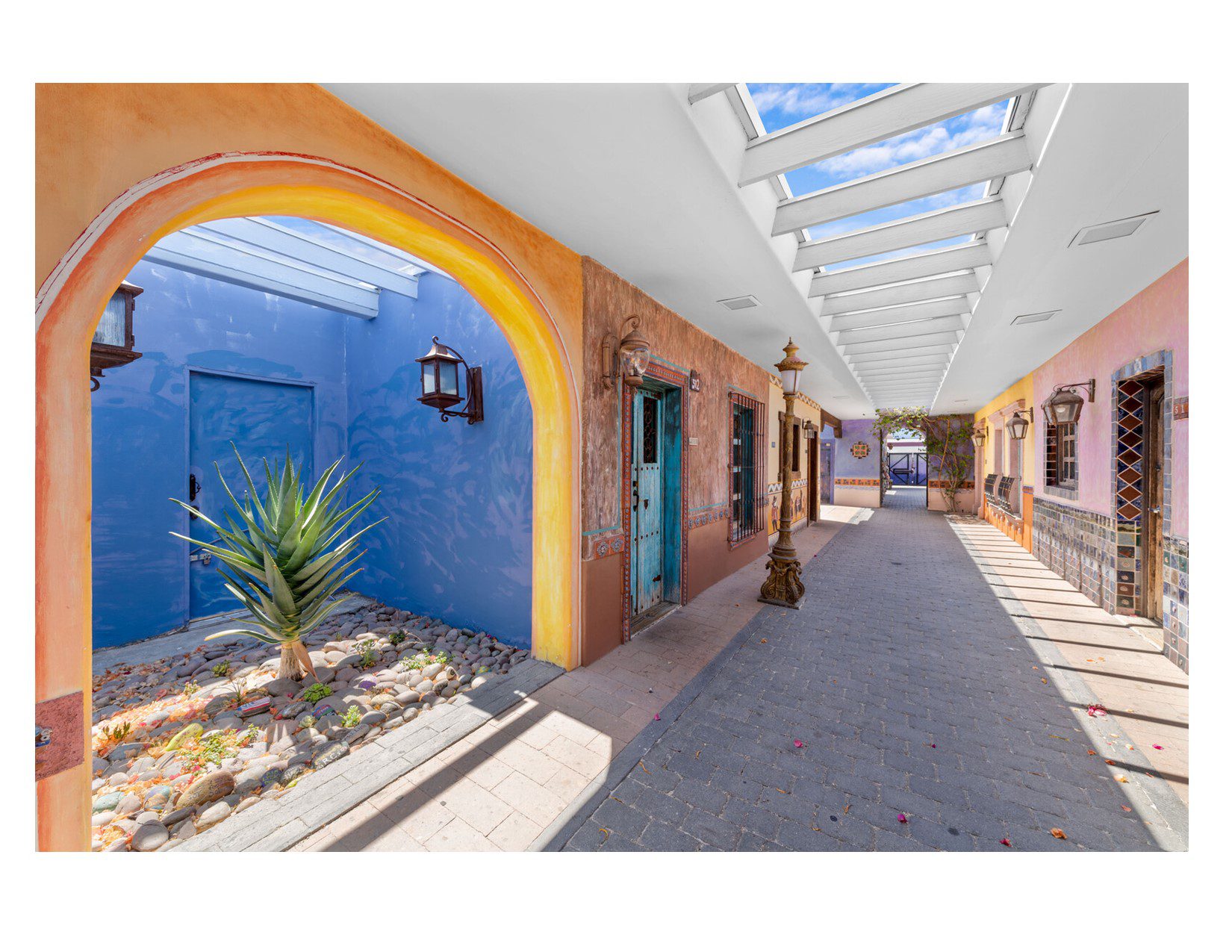 Open-air corridor with colorful walls and skylight