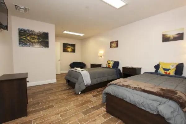 Shared bedroom with two beds and wooden floors.