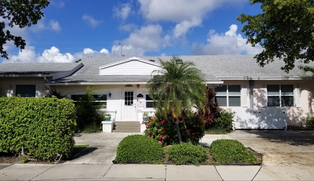 Exterior view of facility with greenery and palm trees