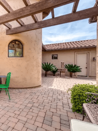 Paved Southwestern-style courtyard with seating, stucco walls, and landscaped plants