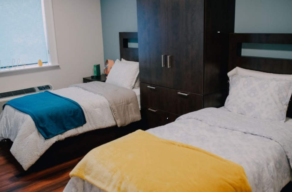 Two neatly made twin beds in a shared rehab bedroom
