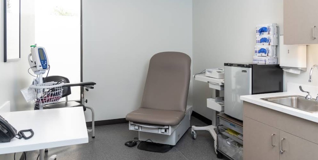 Medical exam room with examination table and sink