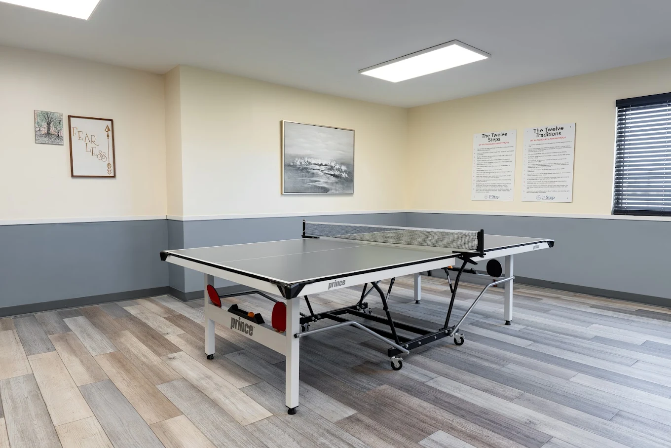 Room with ping pong table and framed recovery posters