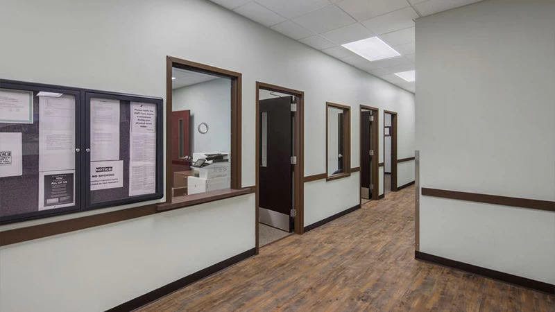 Hallway with office windows and doors along corridor