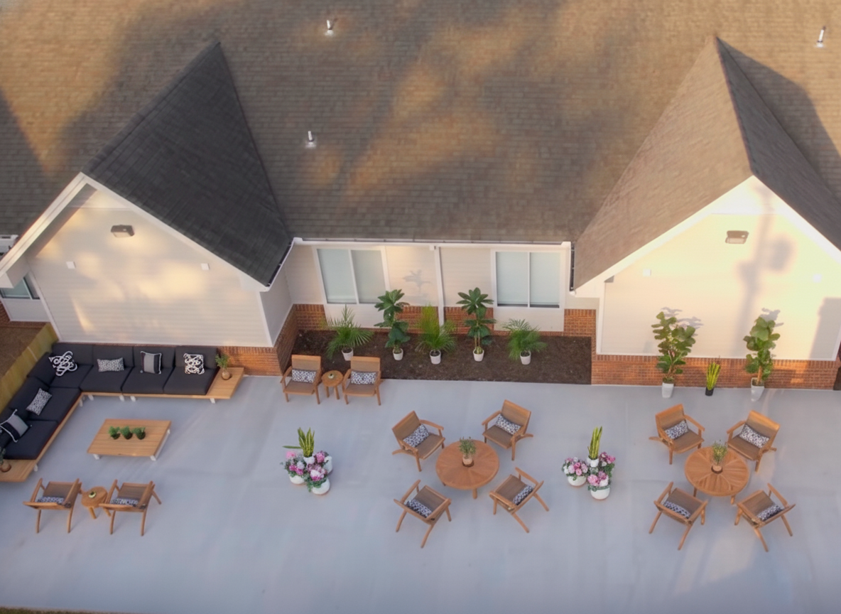 Ground-level view of patio seating and arranged potted plants.