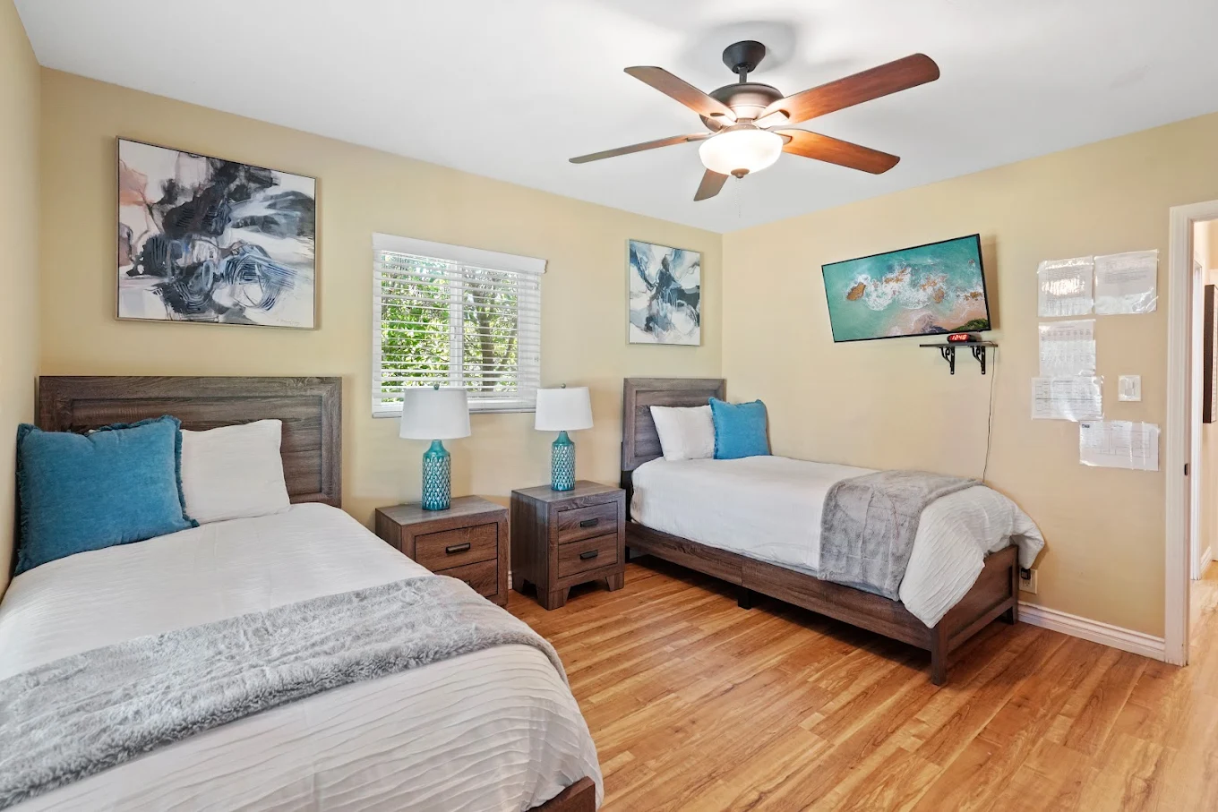 Two twin beds with wood furniture and TV