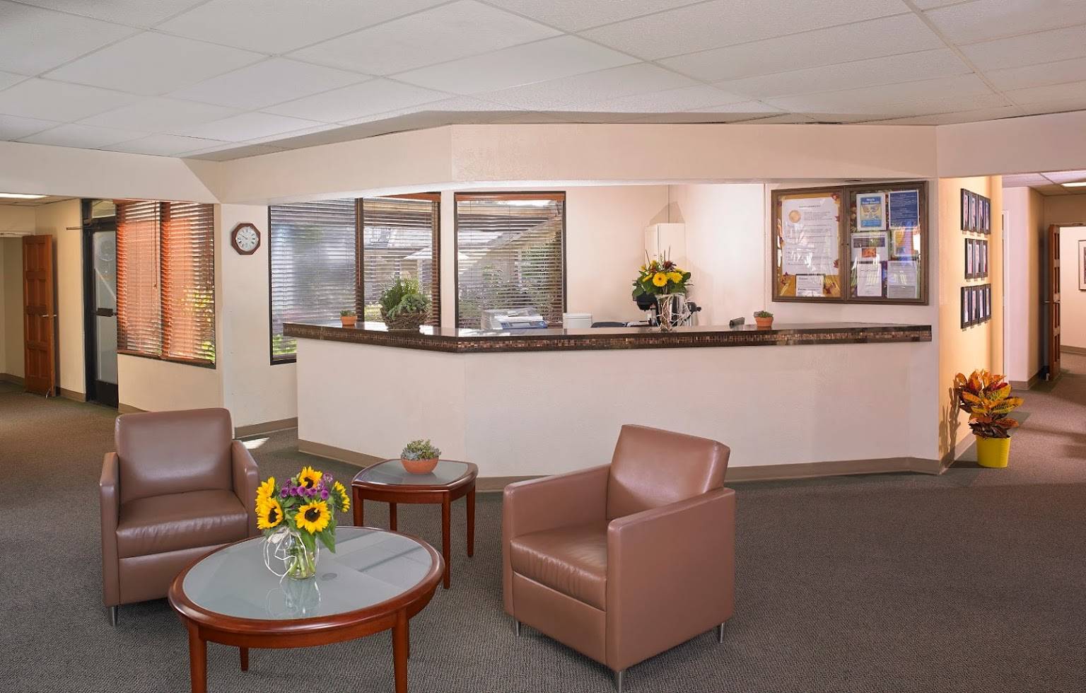 Front desk with brown leather chairs and flowers