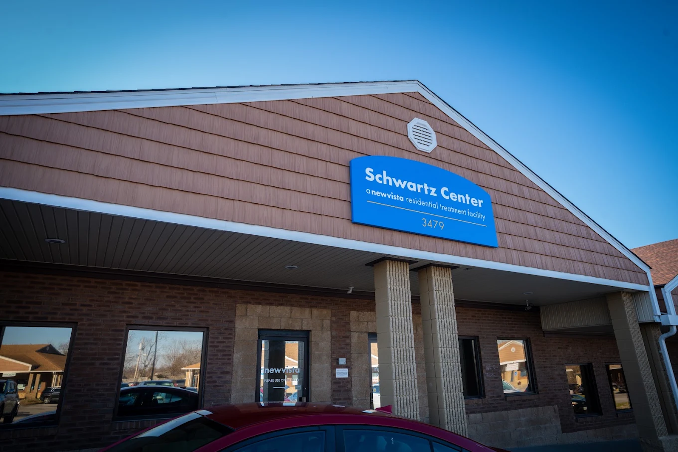 Exterior of Schwartz Center with facility sign and parking