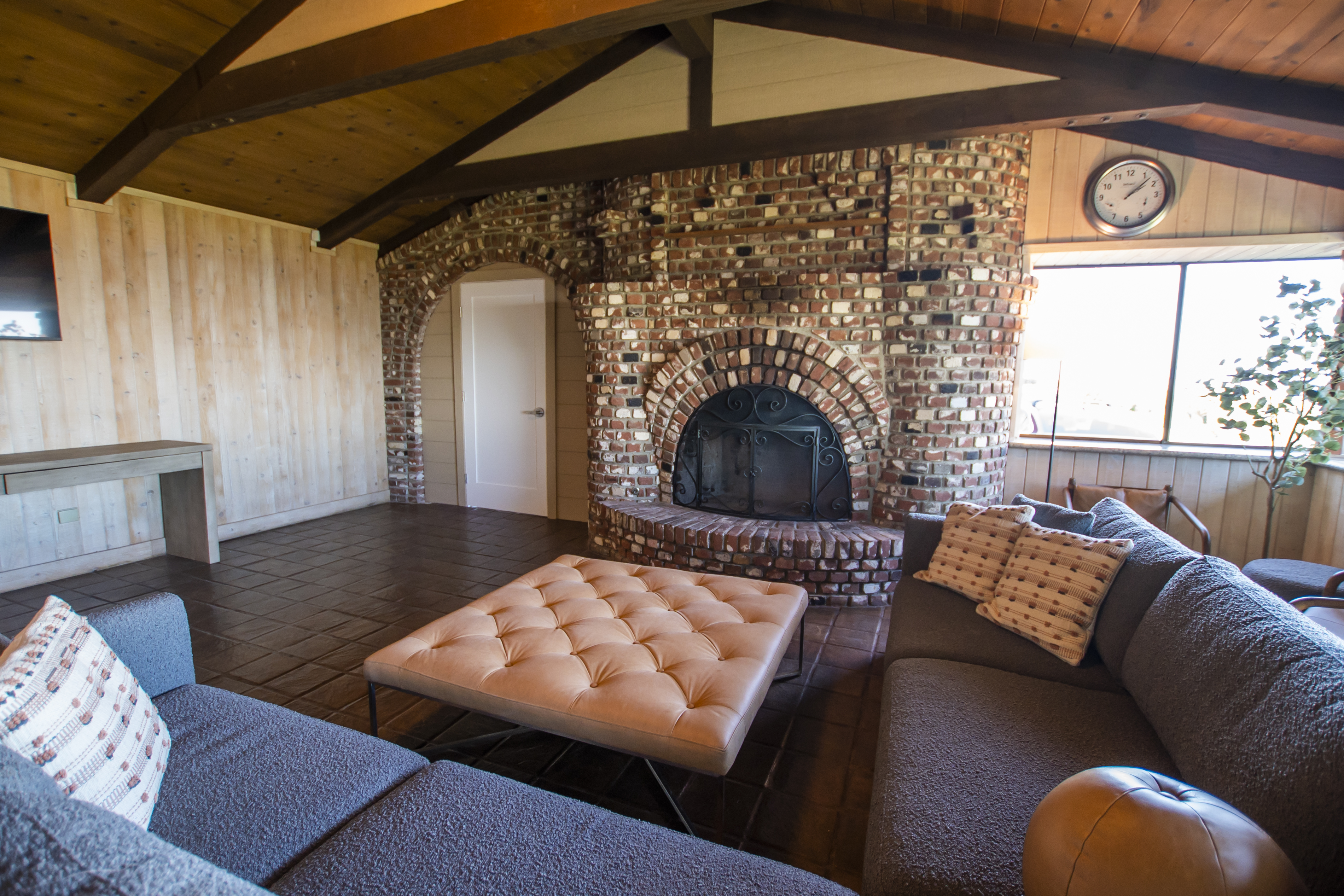 Brick fireplace in cozy lounge with wooden ceiling beams