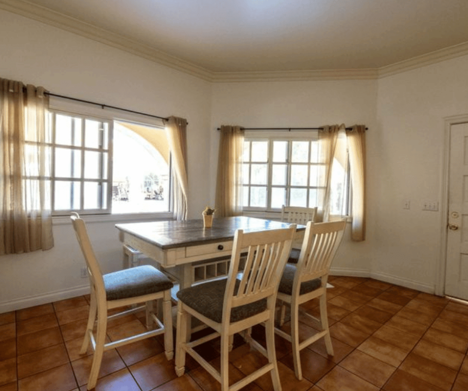 Dining table with chairs and natural light from windows