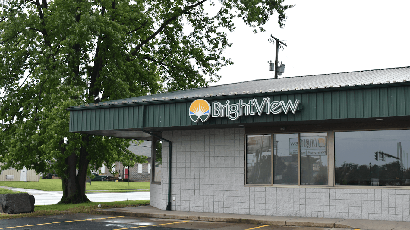 Exterior of BrightView Health Springfield with BrightView signage on a green awning, large windows, and a tree beside the building
