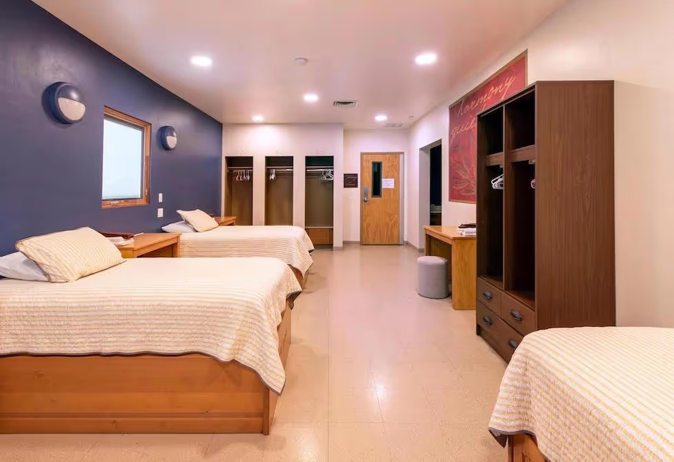 Shared rehab bedroom with three beds and open closets