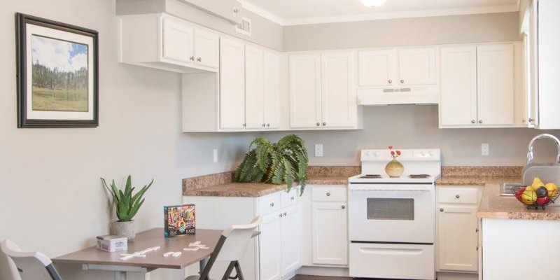 A bright and inviting kitchen with white cabinets, a cozy dining area, and a clean, modern design that promotes a comfortable atmosphere.