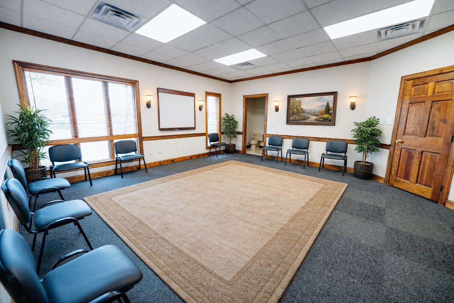 Group therapy room with chairs in circle and rug