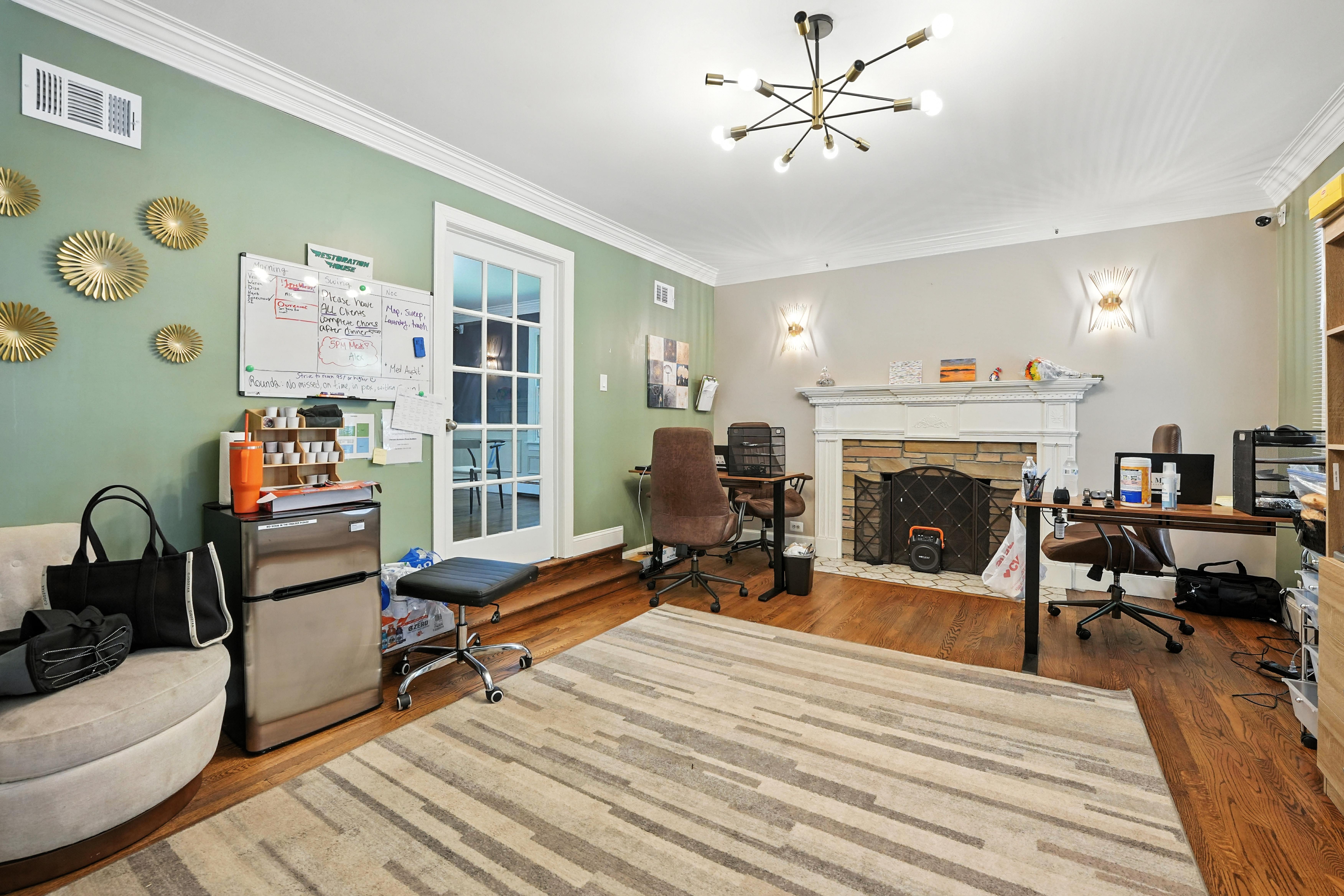 Office room with desks, whiteboard, and fireplace