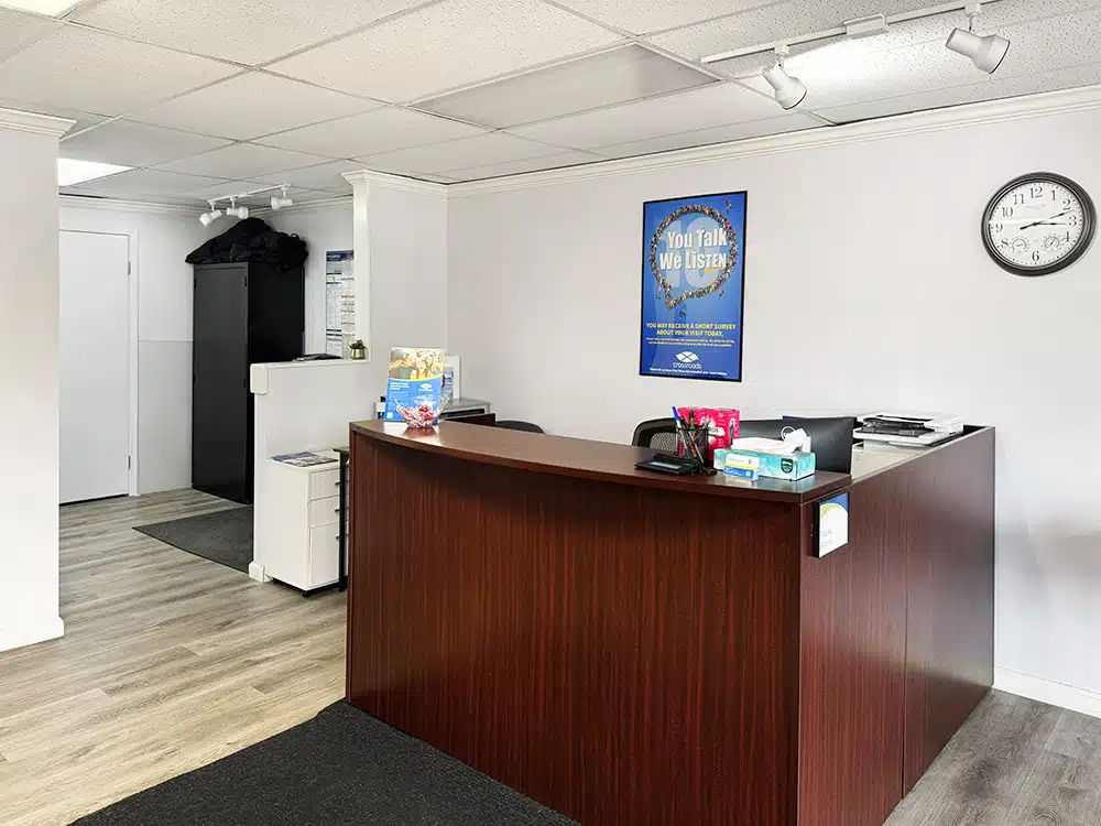 Front desk with office supplies and wall clock behind