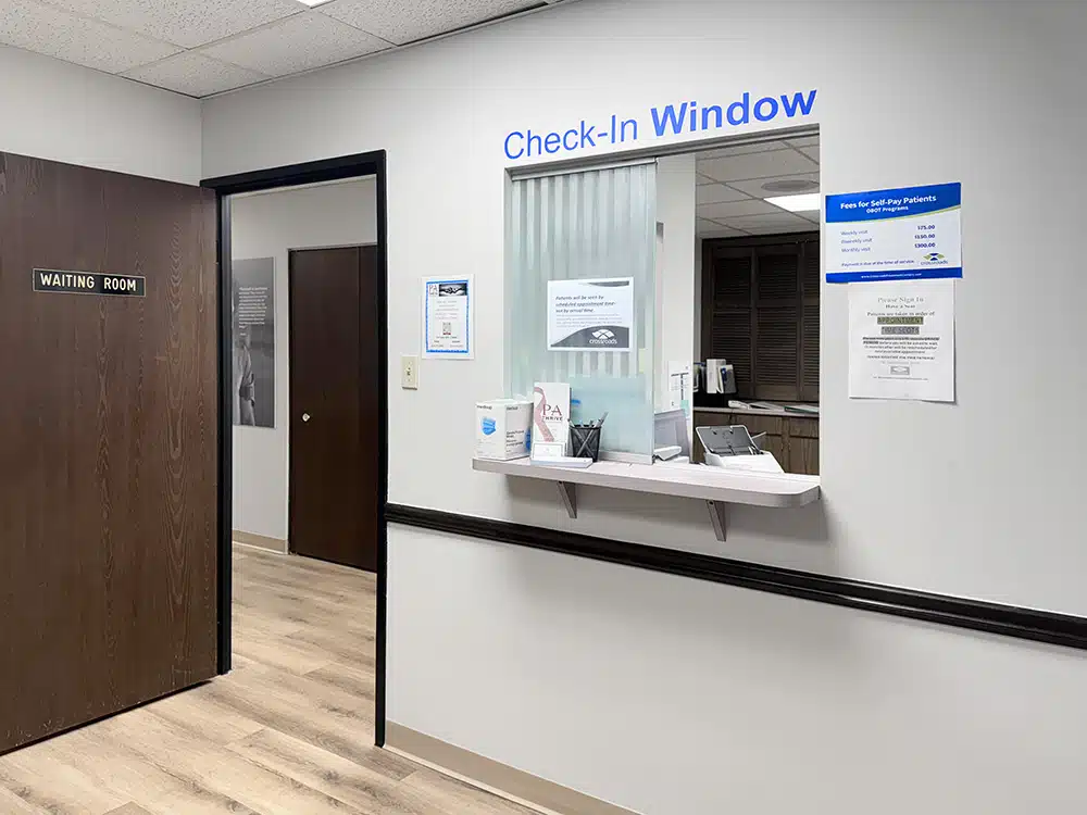 Check-in window next to doorway labeled waiting room