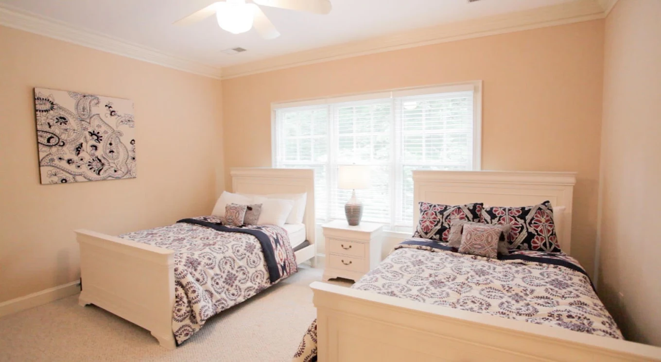 Shared bedroom with two beds and bright windows