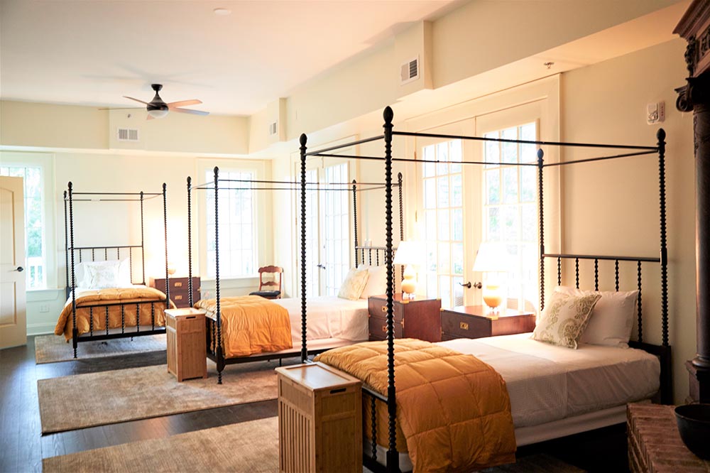 Shared bedroom with canopy beds and natural light