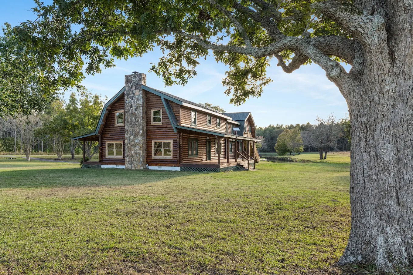Rustic log cabin recovery facility surrounded by lawn and mature trees