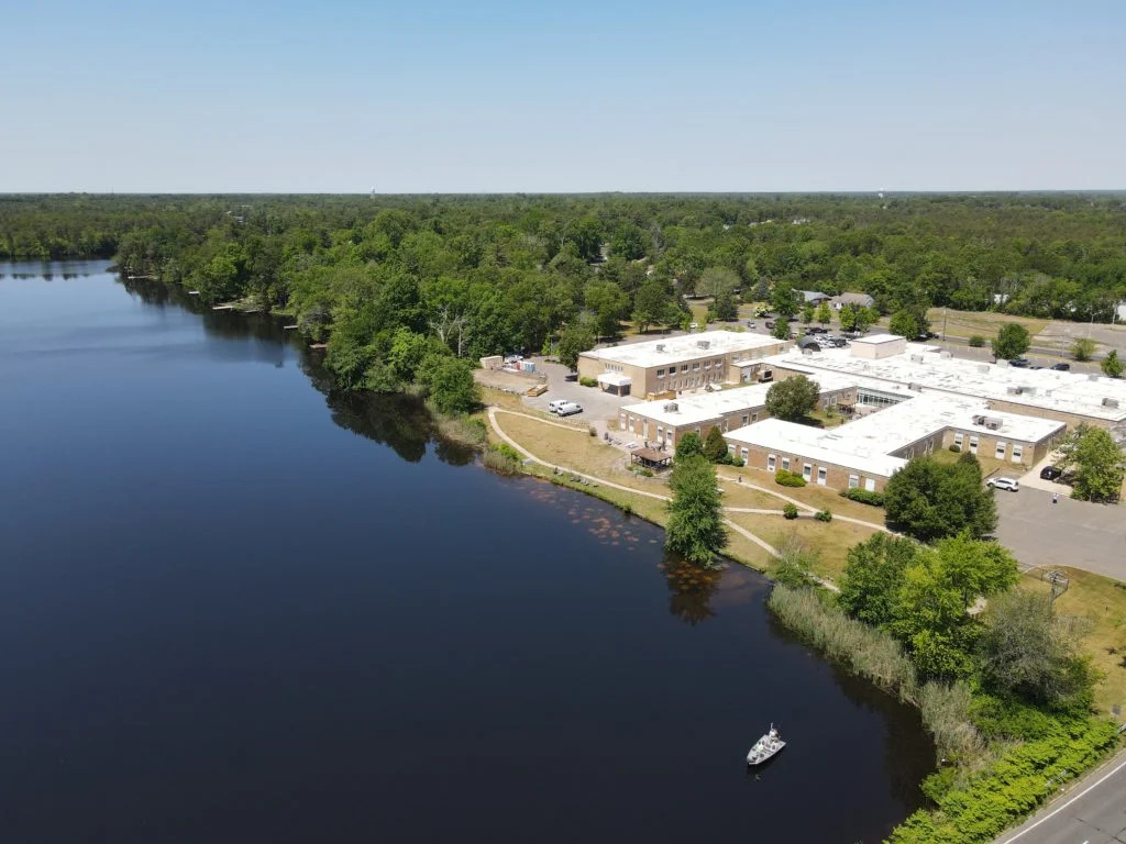 Rehab facility next to a wooded lakeside