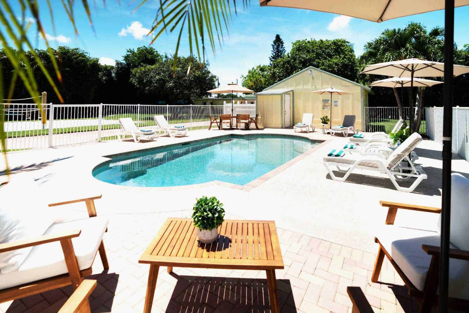 Outdoor pool area with lounge chairs and umbrellas.