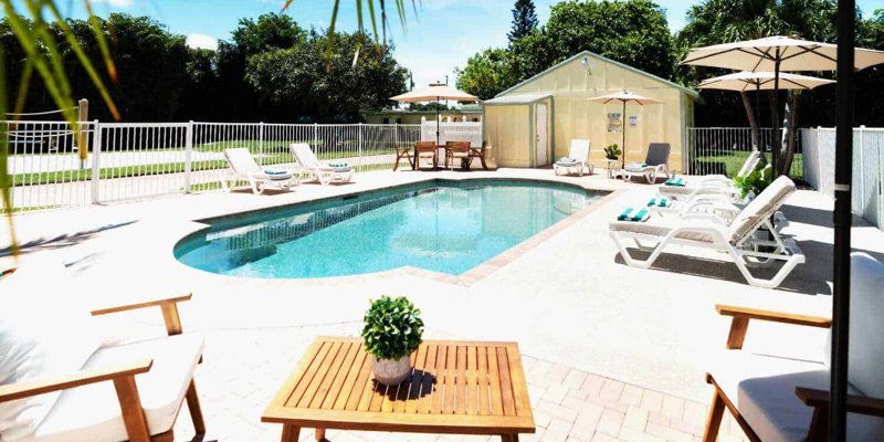 Outdoor pool area with lounge chairs and umbrellas.