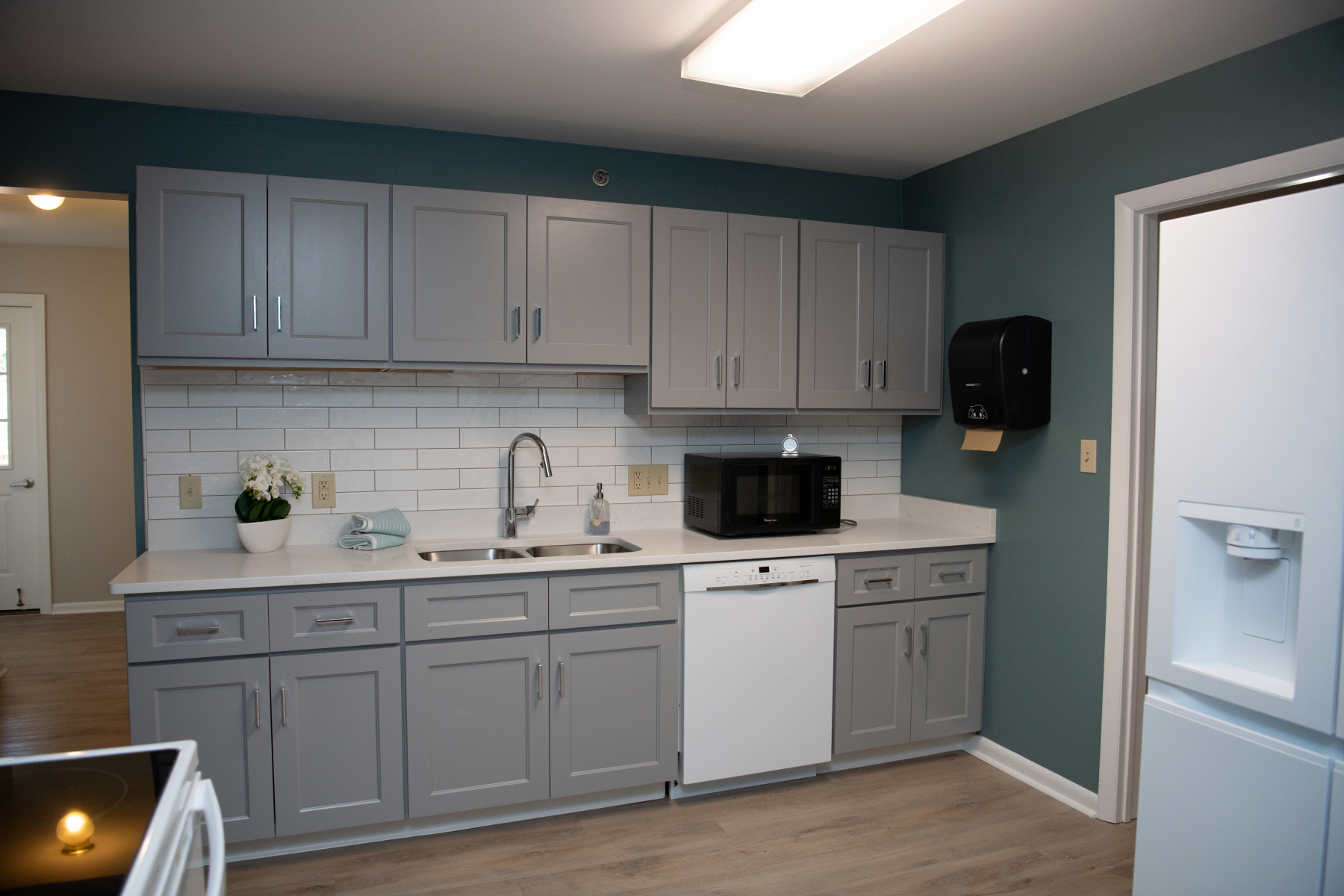 Modern kitchen with gray cabinets and white tile backsplash