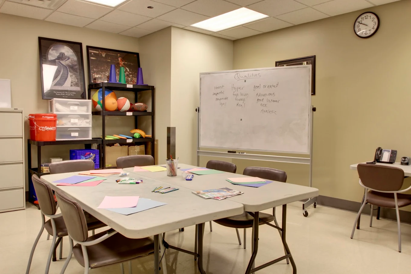 Group therapy room with tables, chairs, and whiteboard.