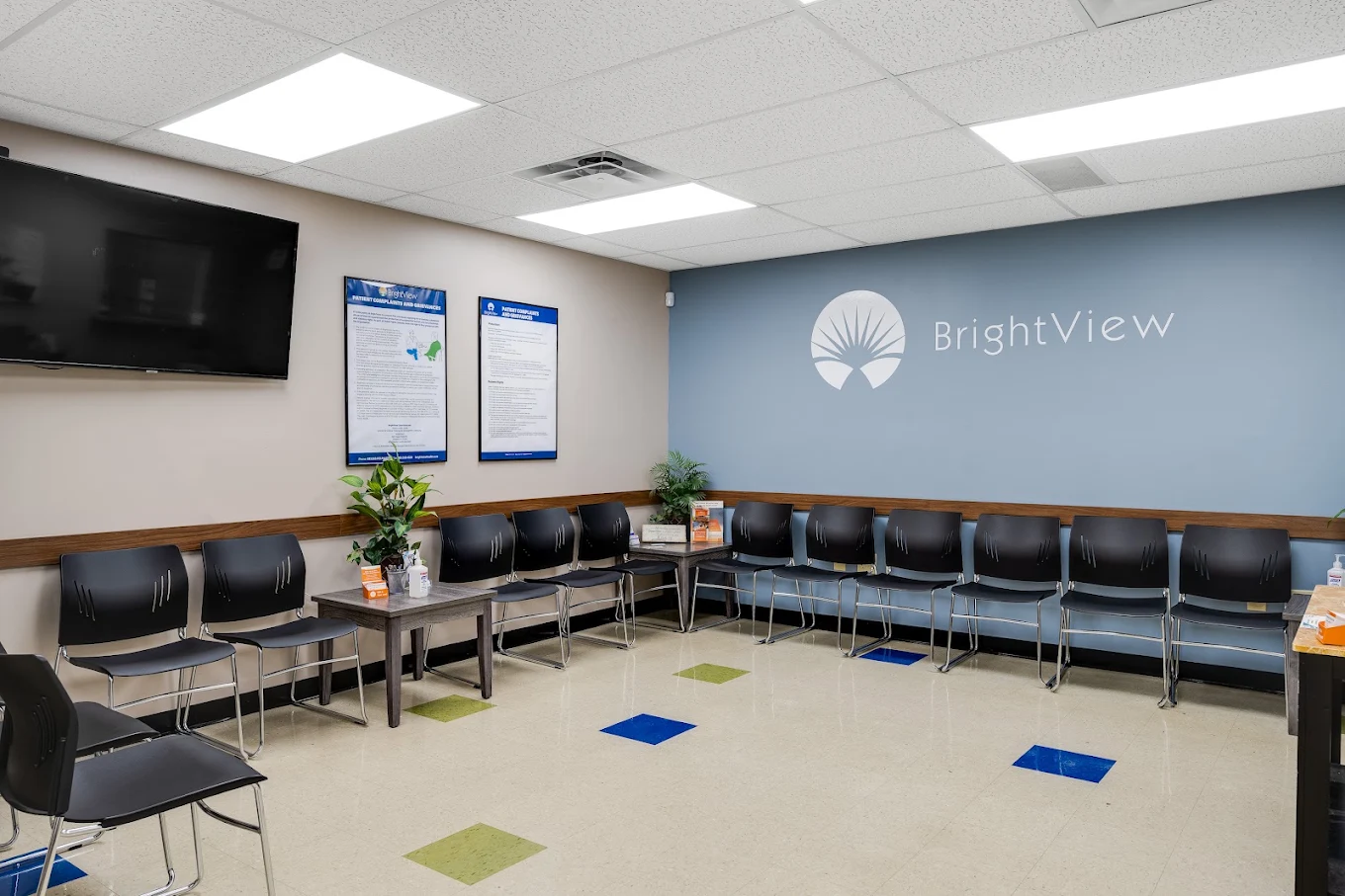 Waiting room with rows of chairs and BrightView logo on blue wall