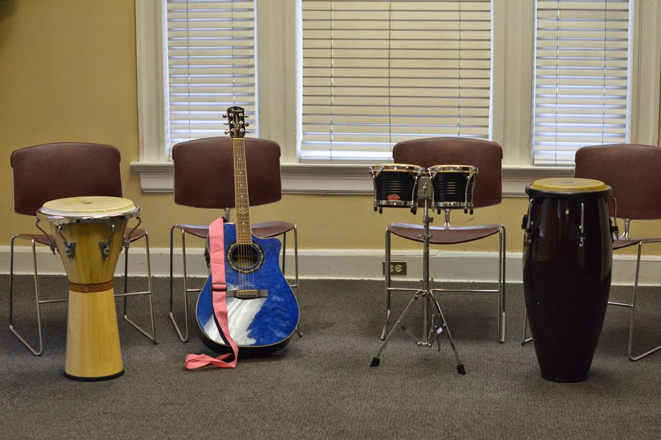 Music therapy room with drums, guitar, and chairs for group sessions