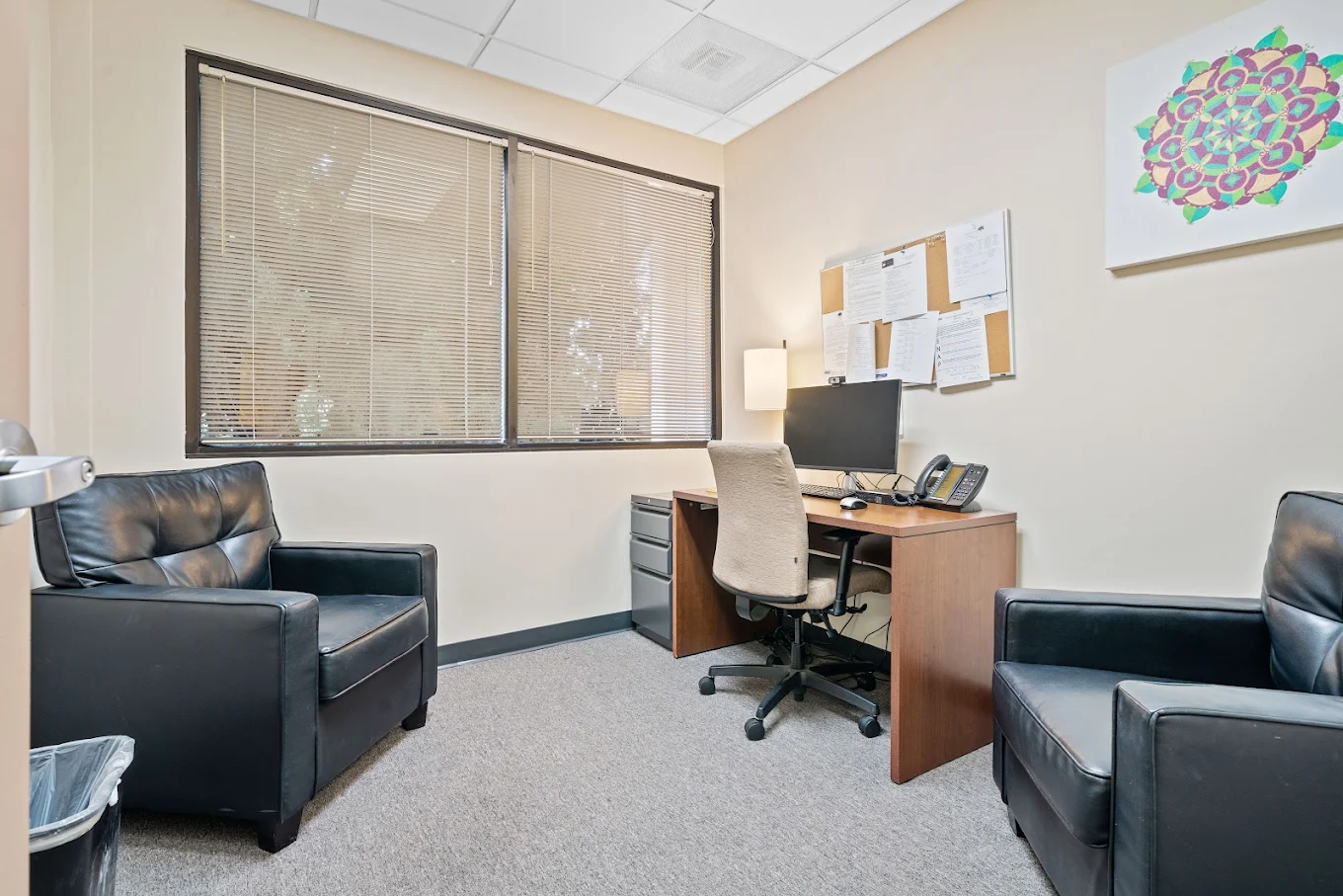 Therapist office with desk, chairs, and window
