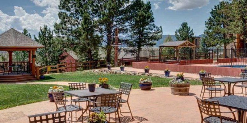 Spacious outdoor patio with a gazebo, garden seating, and scenic mountain views, providing a perfect setting for relaxation and social gatherings.