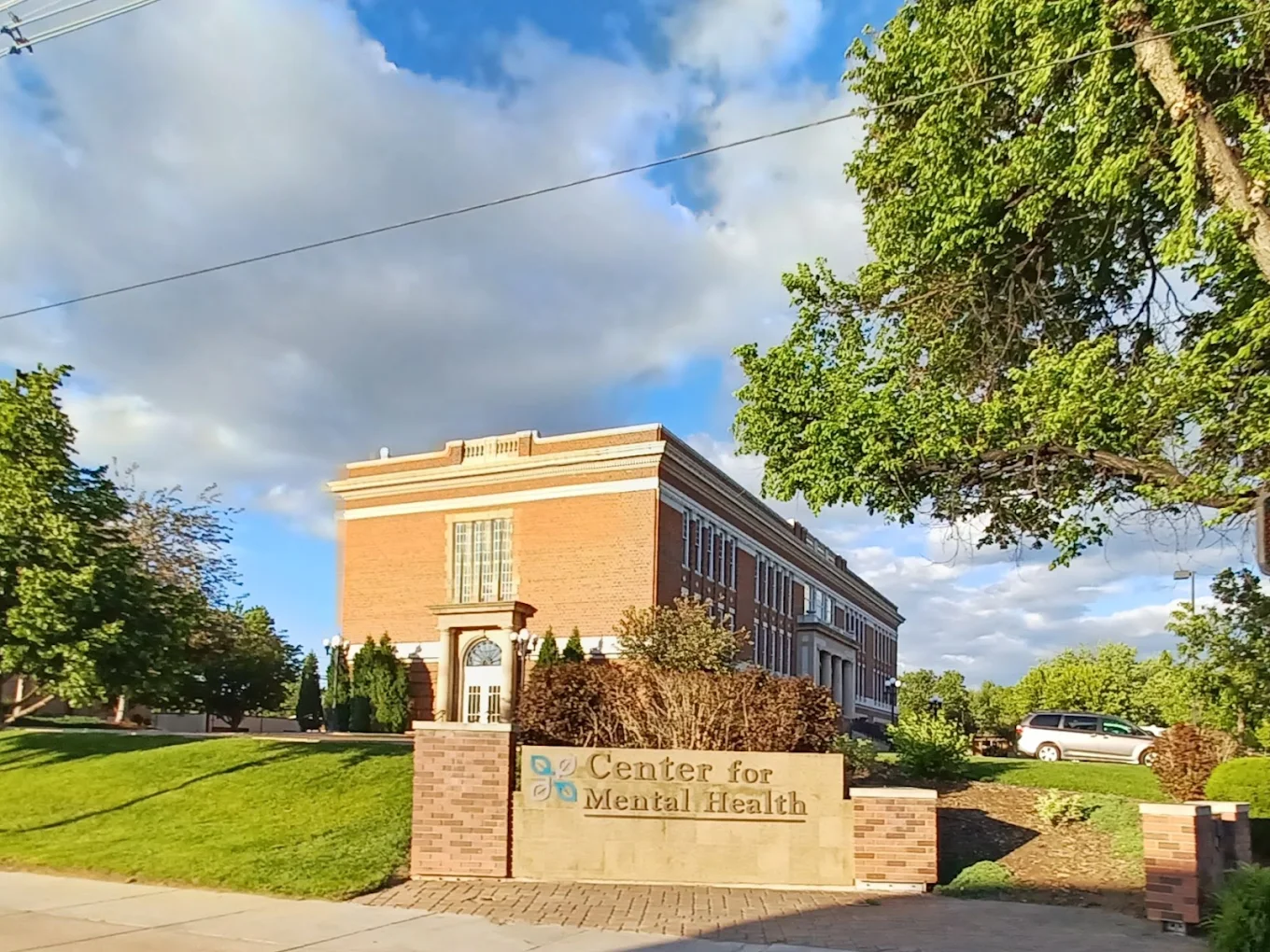 Brick mental health center with front sign and green lawn